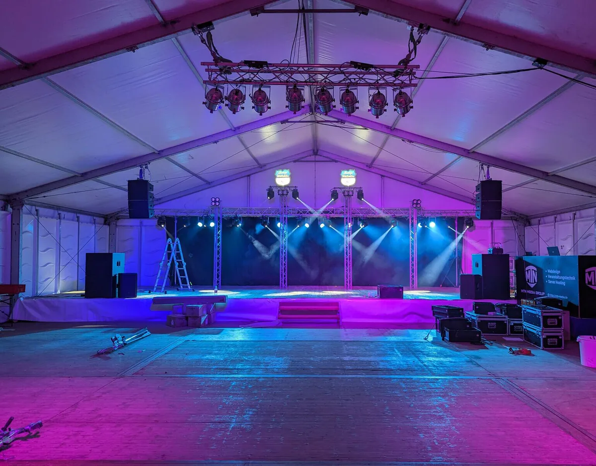 Stage build in blue light with truss towers before doors open