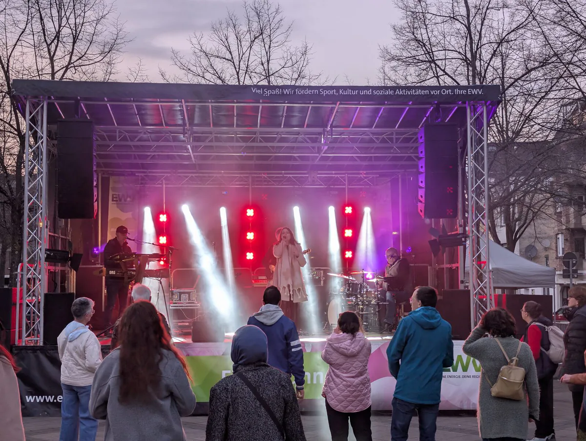 Mobile open-air stage with band, beam looks and PA on the stage wings